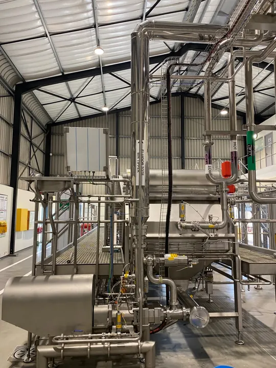 Multiple pipe runs connected around industrial processing equipment